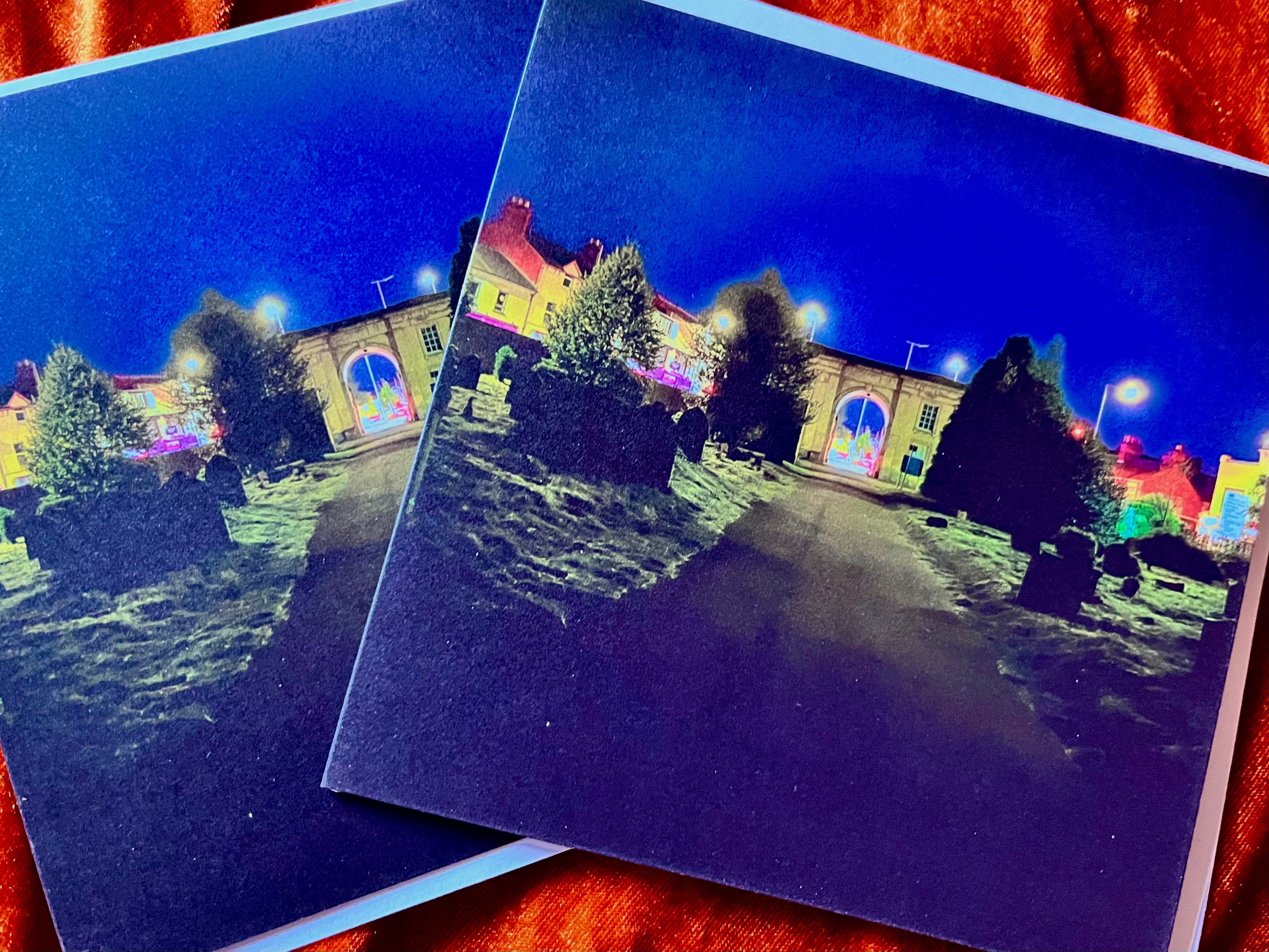 A photograph taken at night inside Reading Old Cemetery looking towards the famous archway.Illumated by street lights and traffic lights outside at Cemetery Junction, Reading.