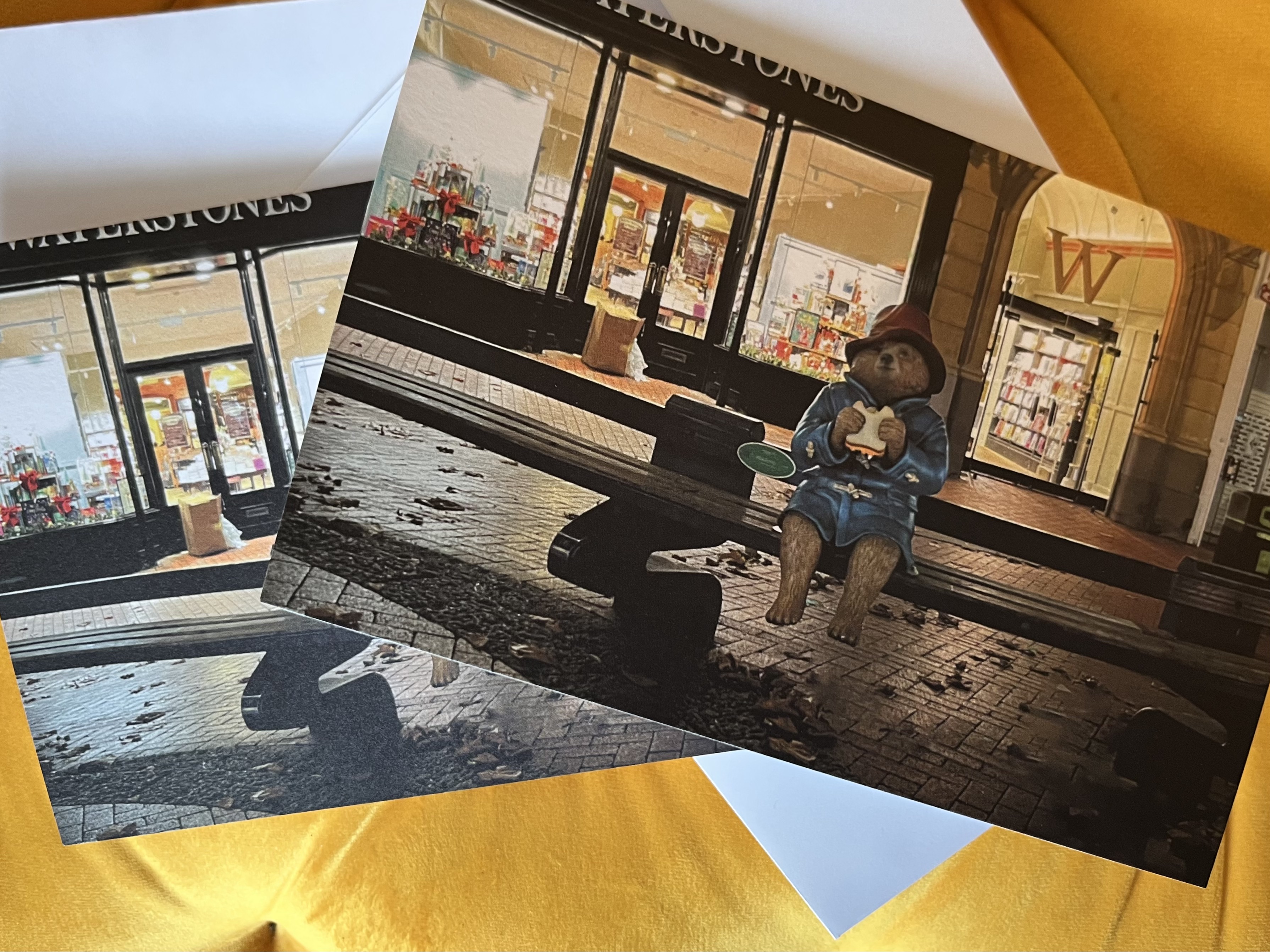 A photograph of Paddington Bear sitting on a bench outside of Waterstones on Broad Street Reading.