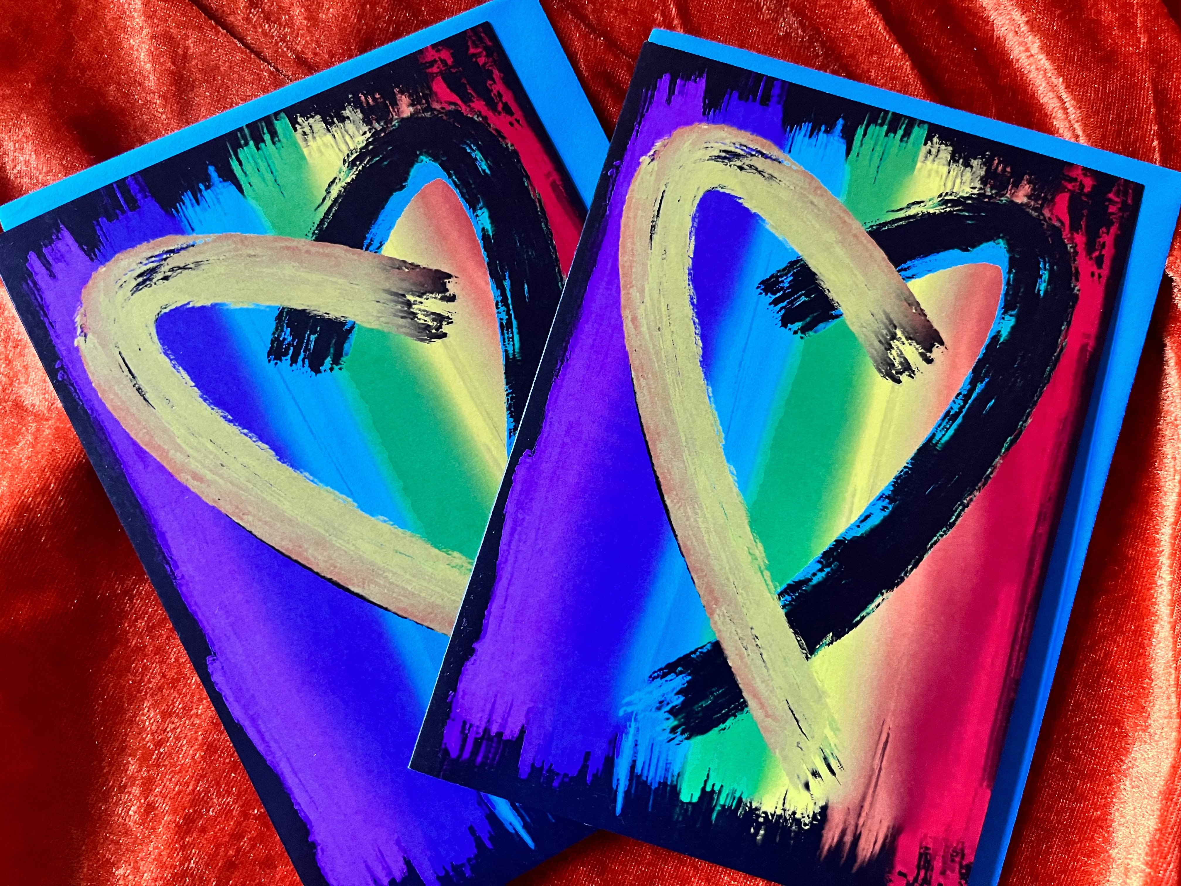 A digital painting of a heart, in two paint strokes, one yellow, one black. In the background there is a painting of a vertical Rainbow flag.